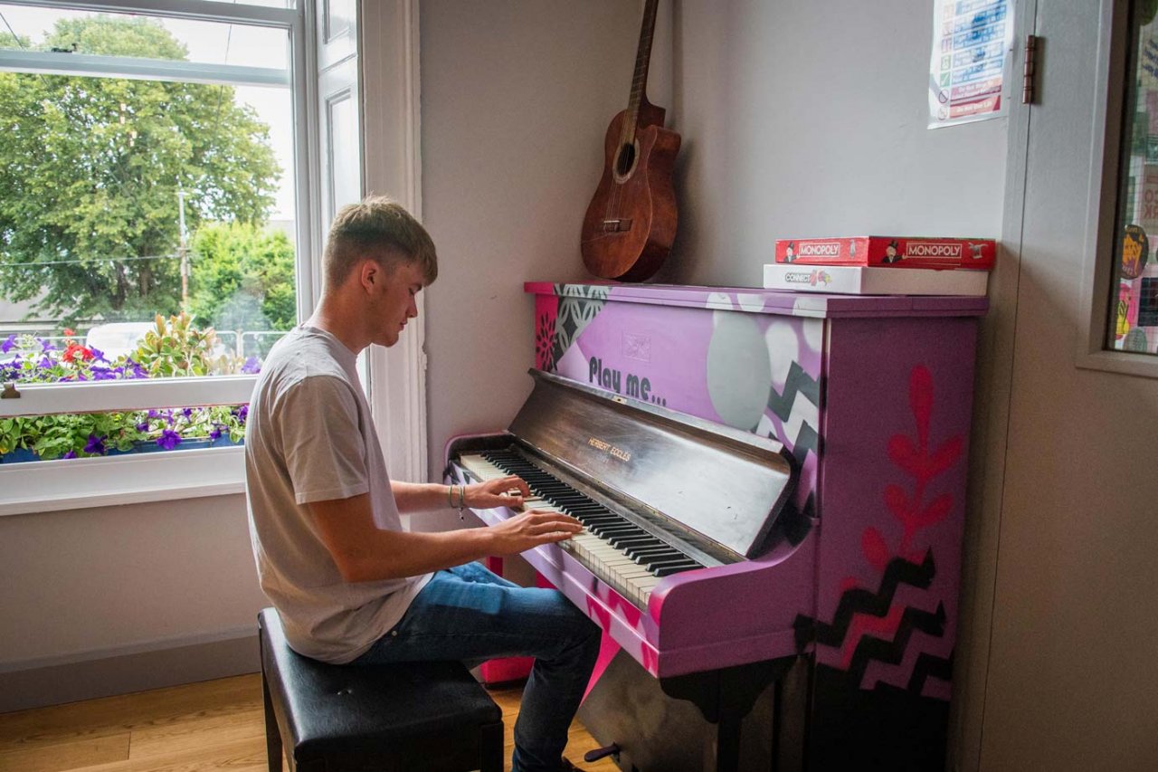 Common Area - Sheilas Hostel in Cork Student Playing Piano - Hostel Common Room