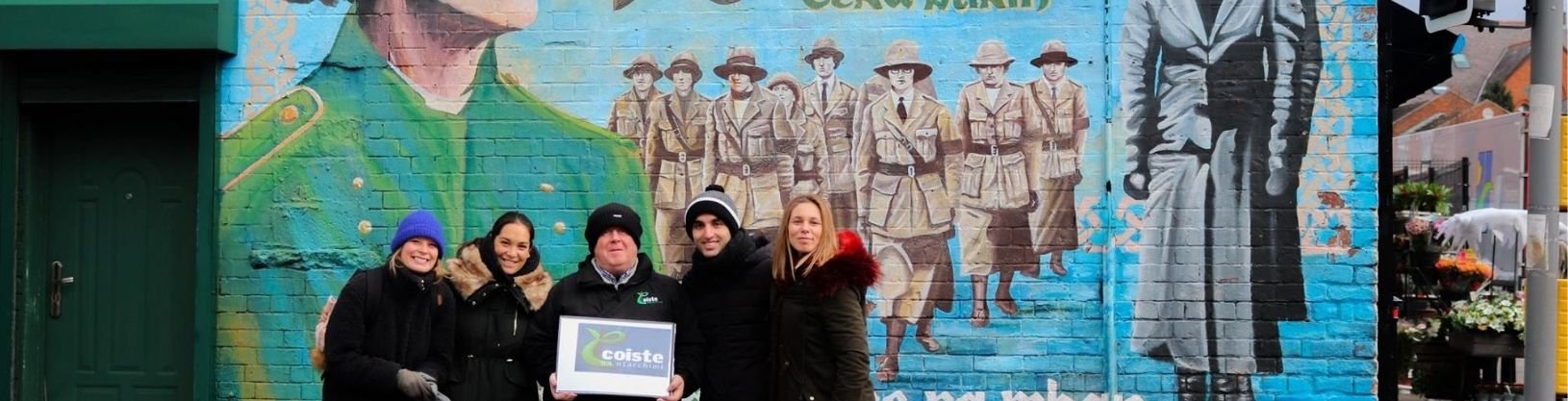 Political walking Tour in Belfast Students with Coiste guide standing in front of political mural in Belfast